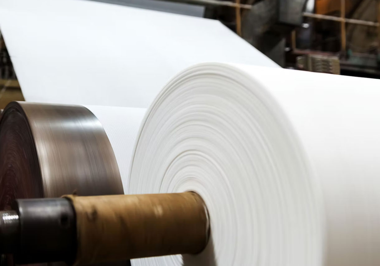 A large roll of stone paper in a factory setting.